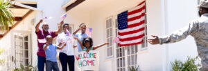 family holding small American flags stands outside to home welcome home their military veteran family member American VA Loans