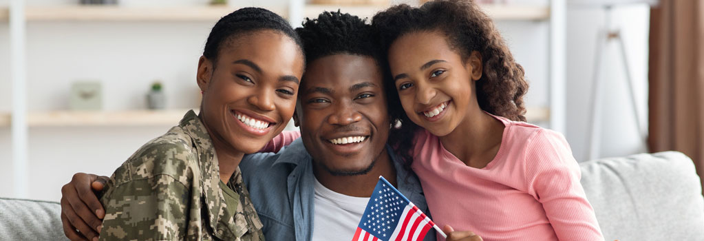 woman military veteran with husband and daughter pose on couch at home American VA Loans