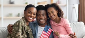 female military veteran smiles with her husband and daughter in their home American VA Loans