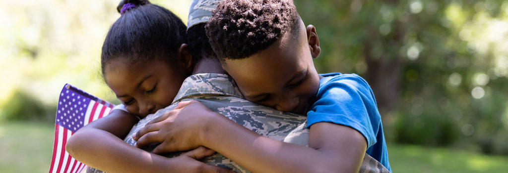 Army veteran hugs his young daughter and son American VA Loans